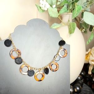 Gold tone, black disk and tortoise shell circles